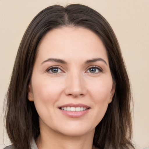 Joyful white young-adult female with long  brown hair and brown eyes