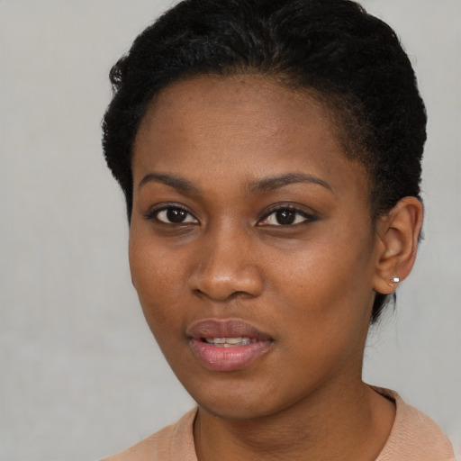 Joyful black young-adult female with short  brown hair and brown eyes