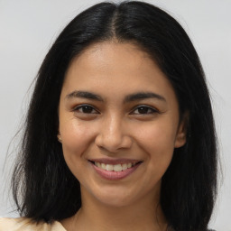 Joyful latino young-adult female with long  brown hair and brown eyes