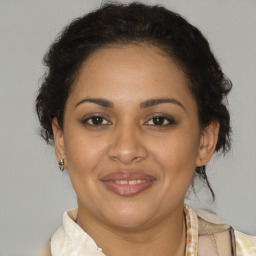 Joyful latino adult female with medium  brown hair and brown eyes