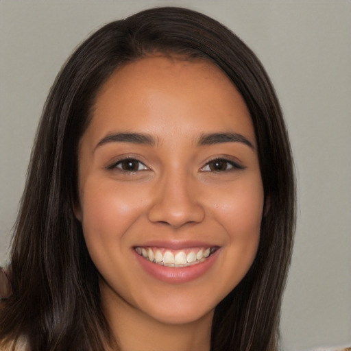 Joyful latino young-adult female with long  brown hair and brown eyes