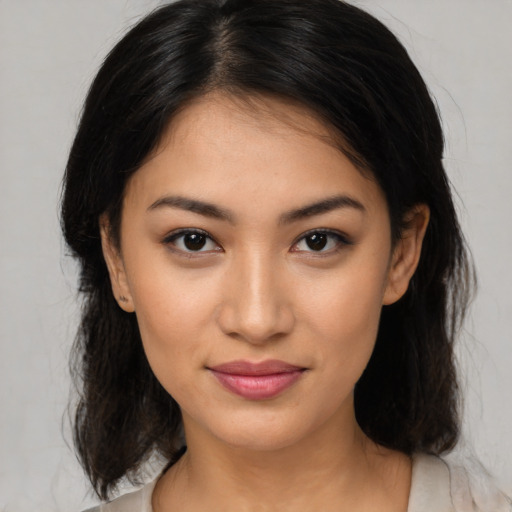 Joyful latino young-adult female with medium  brown hair and brown eyes