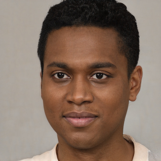 Joyful black young-adult male with short  brown hair and brown eyes