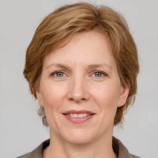 Joyful white adult female with medium  brown hair and grey eyes