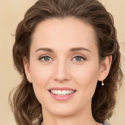 Joyful white young-adult female with medium  brown hair and green eyes