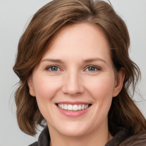 Joyful white young-adult female with medium  brown hair and blue eyes