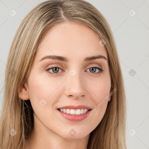 Joyful white young-adult female with long  brown hair and green eyes