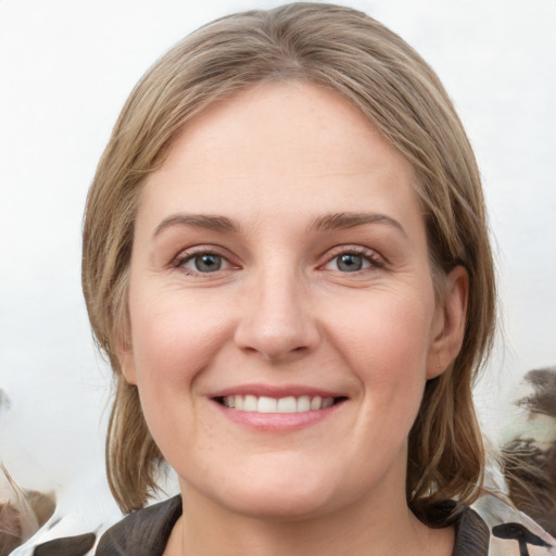 Joyful white young-adult female with medium  brown hair and grey eyes