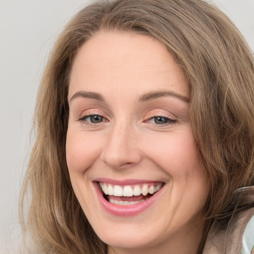 Joyful white young-adult female with long  brown hair and grey eyes