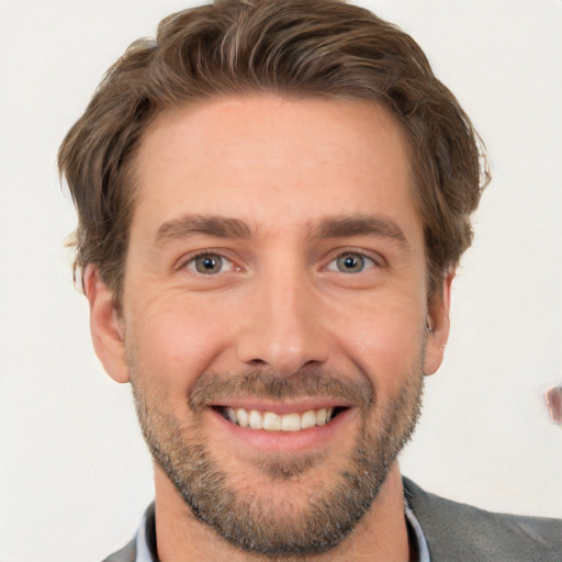 Joyful white young-adult male with short  brown hair and grey eyes