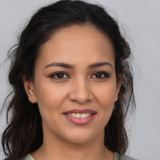 Joyful latino young-adult female with medium  brown hair and brown eyes