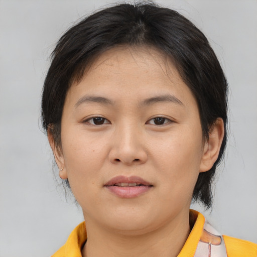 Joyful asian young-adult female with short  brown hair and brown eyes