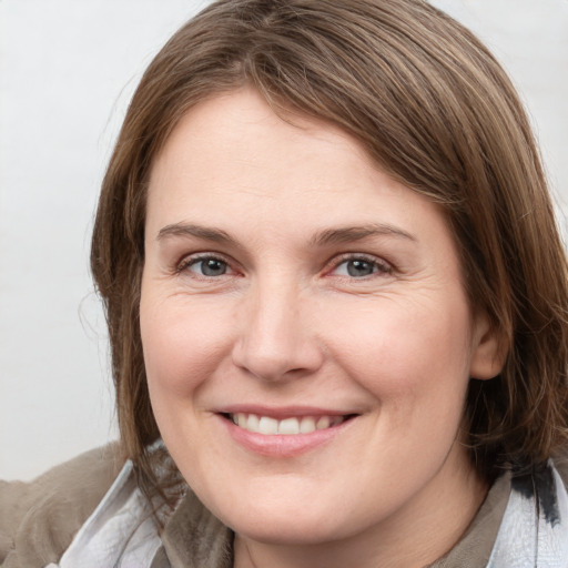 Joyful white young-adult female with medium  brown hair and grey eyes