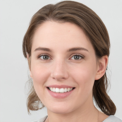 Joyful white young-adult female with medium  brown hair and grey eyes