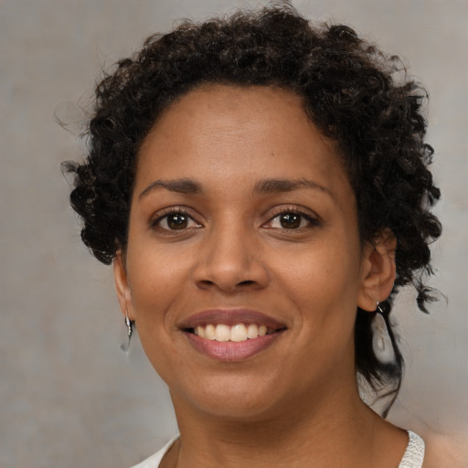 Joyful black young-adult female with medium  brown hair and brown eyes