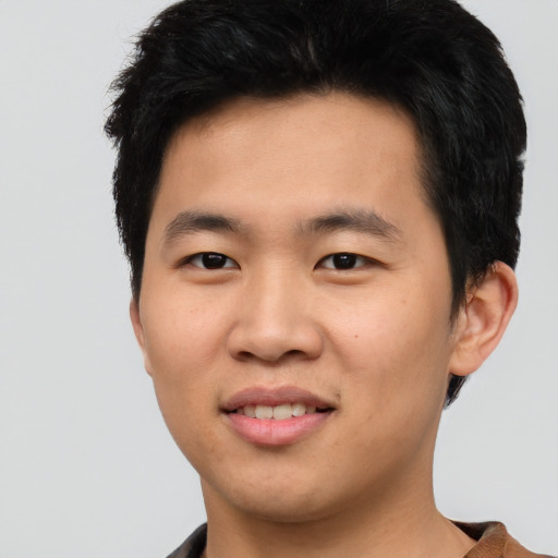 Joyful asian young-adult male with short  black hair and brown eyes
