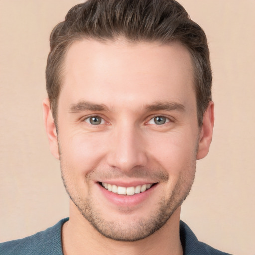 Joyful white young-adult male with short  brown hair and grey eyes