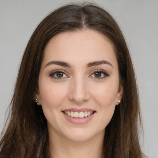 Joyful white young-adult female with long  brown hair and green eyes