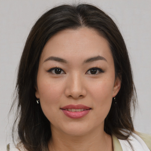 Joyful asian young-adult female with medium  brown hair and brown eyes
