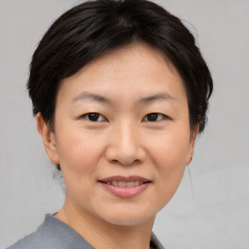 Joyful asian young-adult female with short  brown hair and brown eyes