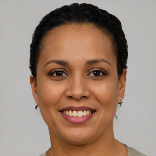 Joyful latino adult female with short  brown hair and brown eyes