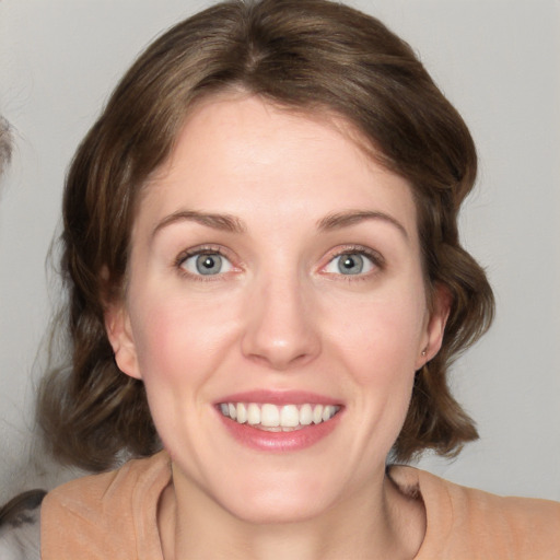 Joyful white young-adult female with medium  brown hair and blue eyes