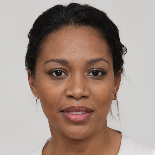 Joyful black young-adult female with short  black hair and brown eyes