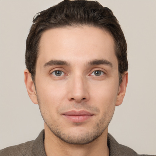 Joyful white young-adult male with short  brown hair and grey eyes