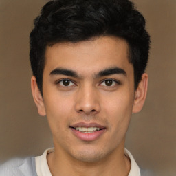 Joyful latino young-adult male with short  brown hair and brown eyes