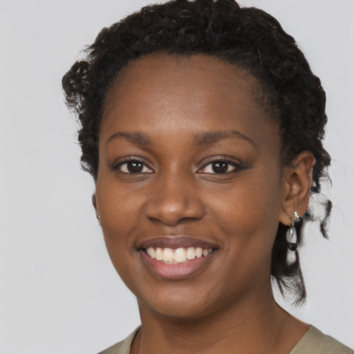 Joyful black young-adult female with medium  black hair and brown eyes