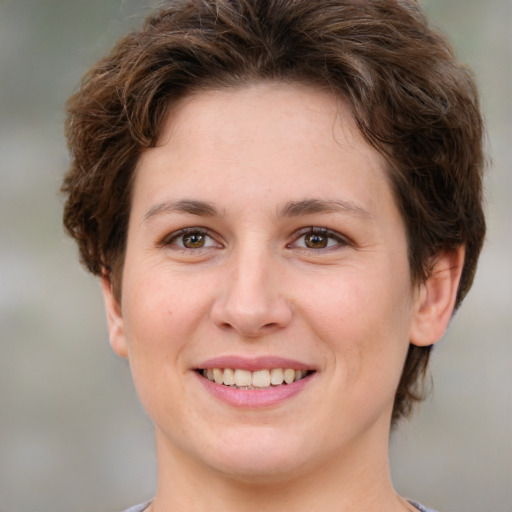 Joyful white young-adult female with short  brown hair and green eyes