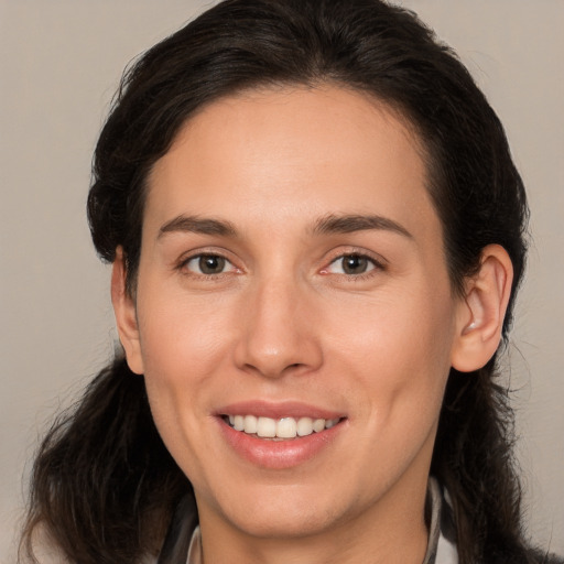 Joyful white young-adult female with long  brown hair and brown eyes