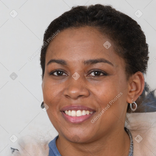 Joyful black young-adult female with short  brown hair and brown eyes