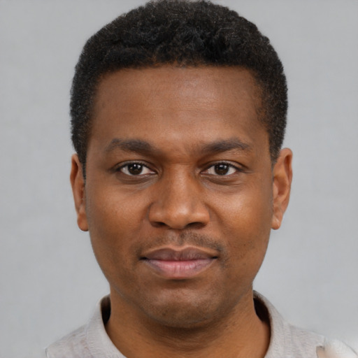 Joyful black young-adult male with short  black hair and brown eyes