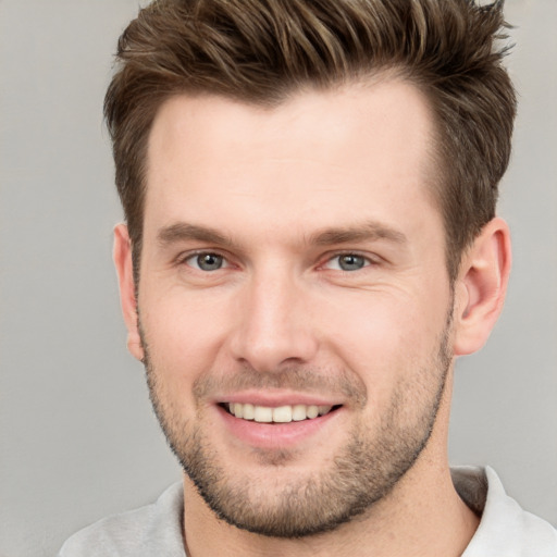 Joyful white young-adult male with short  brown hair and grey eyes