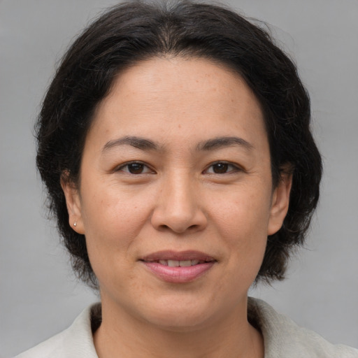 Joyful asian adult female with medium  brown hair and brown eyes