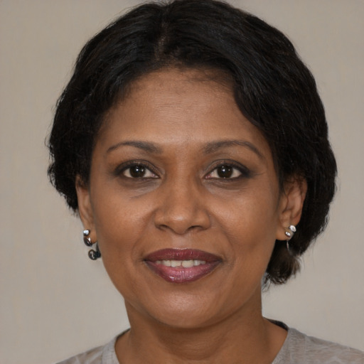 Joyful black adult female with medium  brown hair and brown eyes