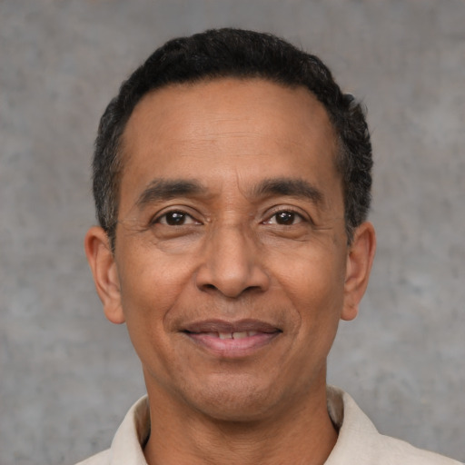 Joyful latino adult male with short  black hair and brown eyes