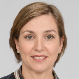 Joyful white young-adult female with medium  brown hair and grey eyes