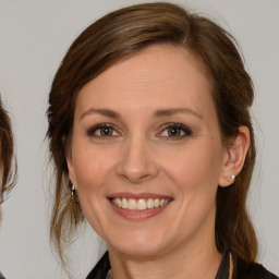 Joyful white young-adult female with medium  brown hair and grey eyes