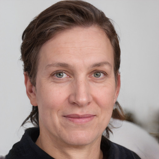 Joyful white adult female with medium  brown hair and grey eyes