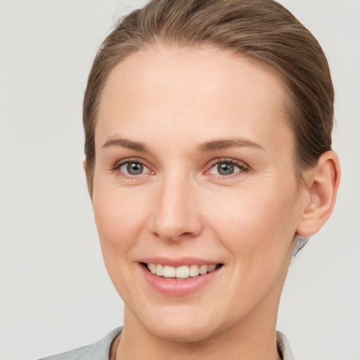 Joyful white young-adult female with short  brown hair and grey eyes