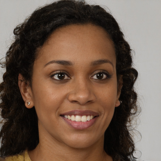Joyful black young-adult female with long  brown hair and brown eyes