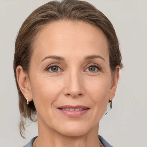 Joyful white adult female with medium  brown hair and grey eyes