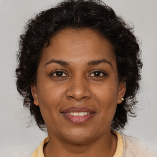 Joyful black adult female with short  brown hair and brown eyes