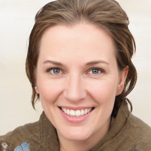 Joyful white young-adult female with medium  brown hair and grey eyes