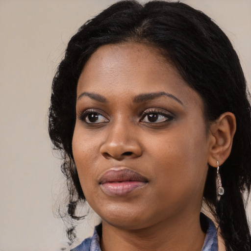 Joyful black young-adult female with long  black hair and brown eyes