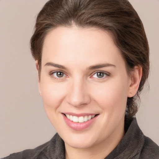 Joyful white young-adult female with medium  brown hair and grey eyes