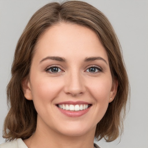 Joyful white young-adult female with medium  brown hair and green eyes