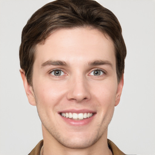 Joyful white young-adult male with short  brown hair and grey eyes